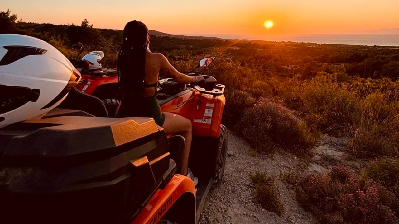 Quad bikes on a dirt track, the sun going down over the coast